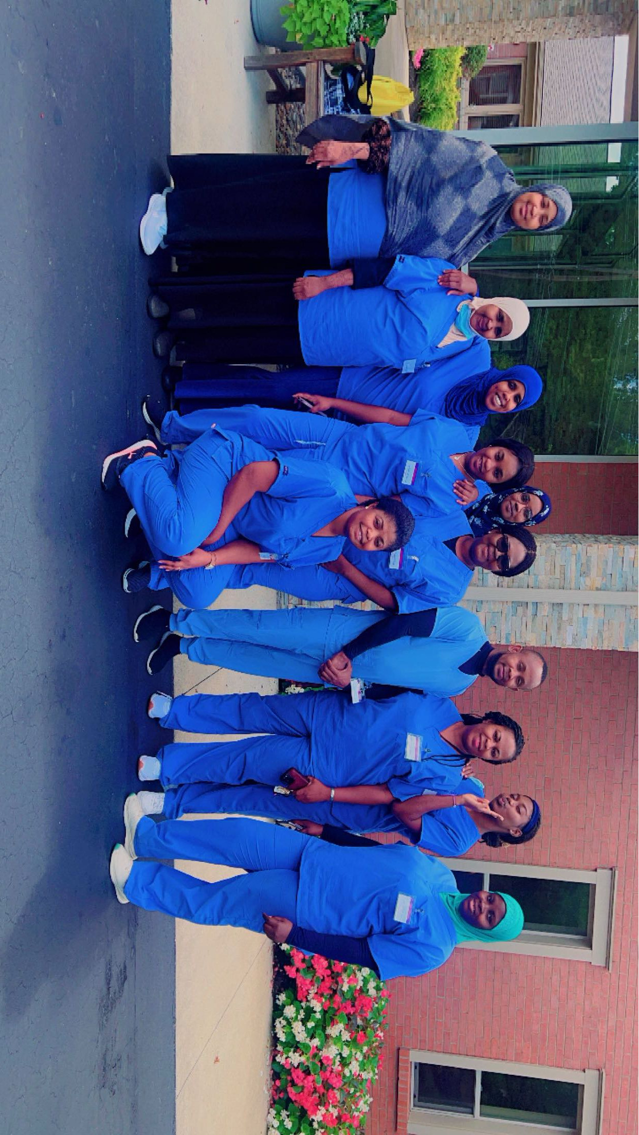 Allure students in blue scrubs gathered outside the training center